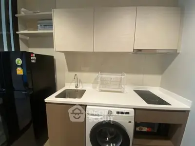 Modern kitchen with sleek appliances and compact design, featuring a washing machine and induction cooktop.