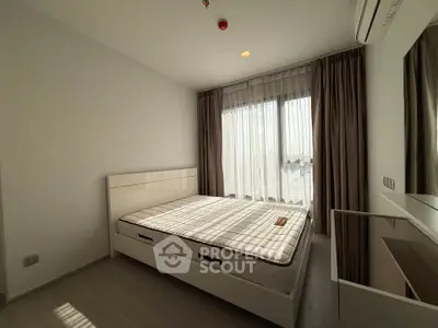 Modern bedroom with natural light and minimalist design, featuring a comfortable bed and stylish curtains.