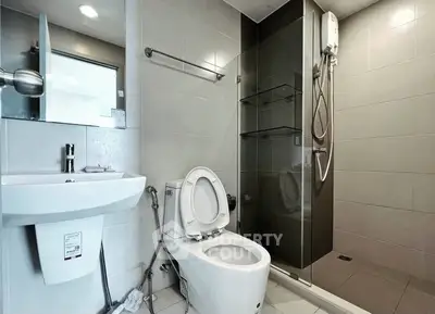 Modern bathroom with sleek fixtures and walk-in shower in contemporary apartment.