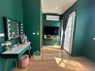 Chic modern living room with green walls, stylish vanity, and large TV, perfect for urban living.