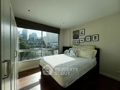 Cozy bedroom with city view, featuring a comfortable bed and stylish decor.