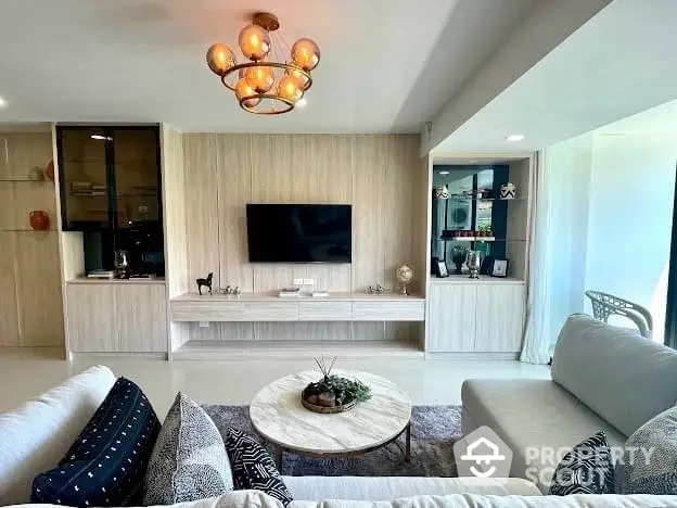 Elegant living room with modern furnishings, ambient lighting, and a seamless transition to an open kitchen, perfect for entertaining and relaxation.