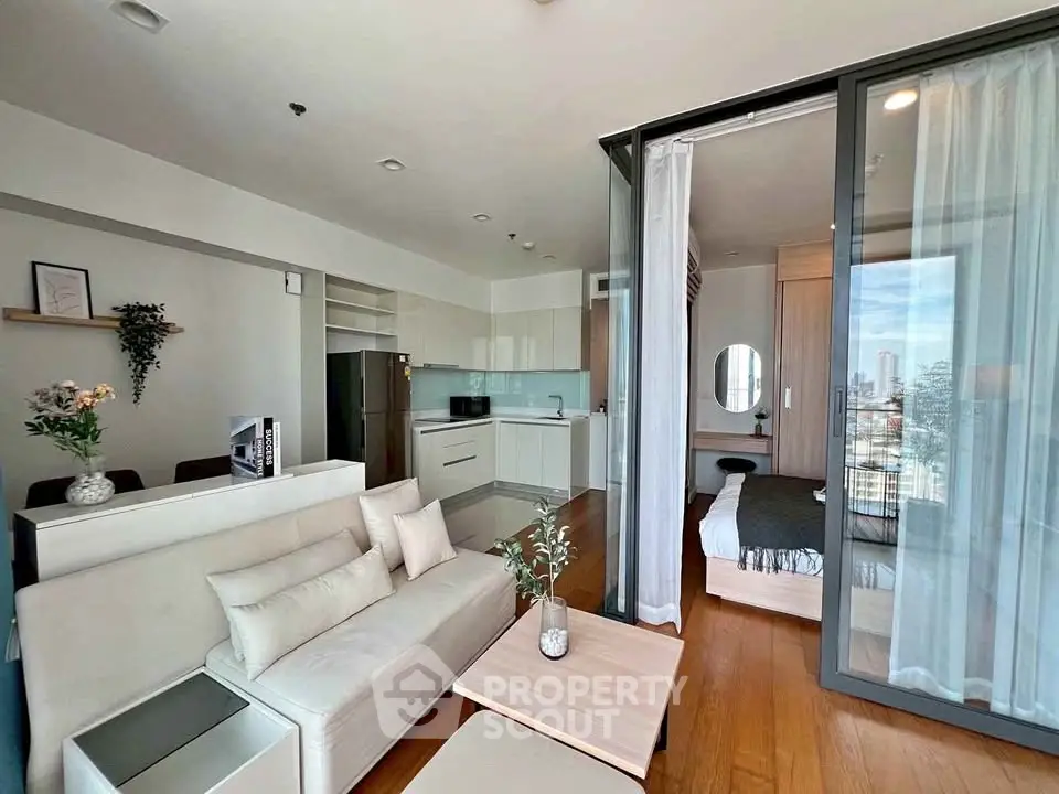 Modern open-plan living room and kitchen with city view, featuring sleek furniture and elegant decor.