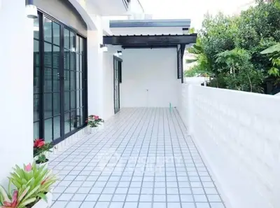 Spacious modern balcony with sleek tiles and lush greenery, perfect for relaxation and outdoor gatherings.