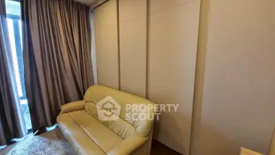 Cozy living room with beige sofa and floor-to-ceiling curtains, perfect for relaxation.