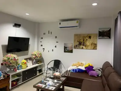 Cozy living room with modern decor, wall-mounted TV, and comfortable seating area.