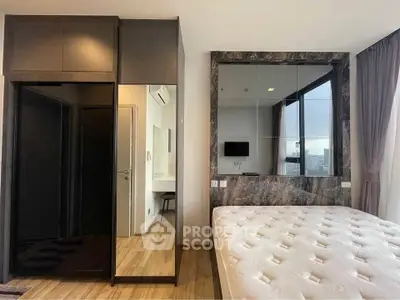 Modern bedroom with large mirrored wardrobe and natural light