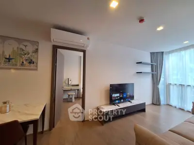 Modern living room with sleek TV setup and stylish decor in a bright apartment.