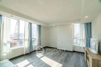 Bright and spacious living room with large windows and modern flooring