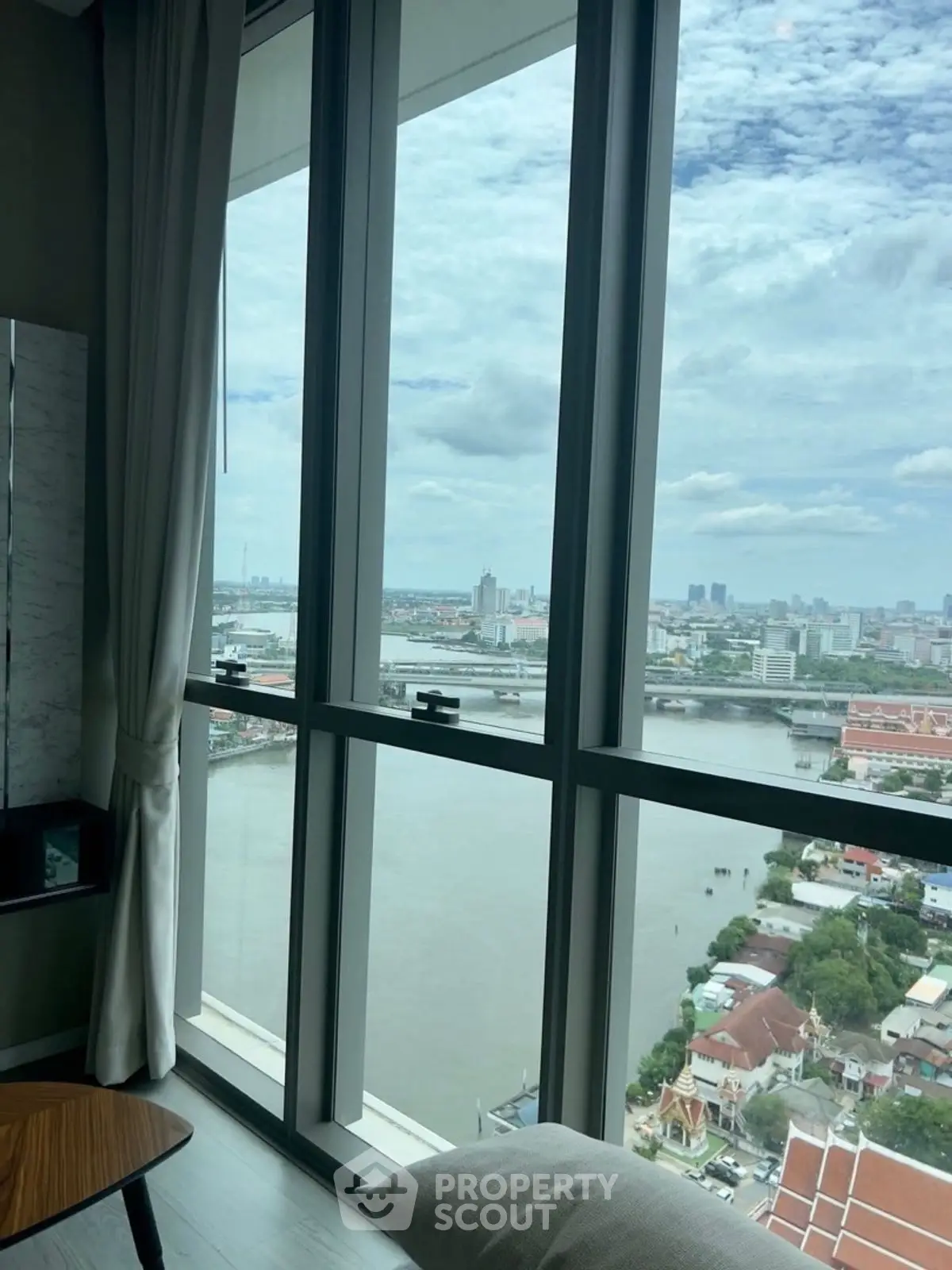 Stunning river view from high-rise apartment window with city skyline.