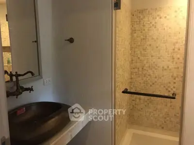 Modern bathroom with stylish sink and tiled shower area
