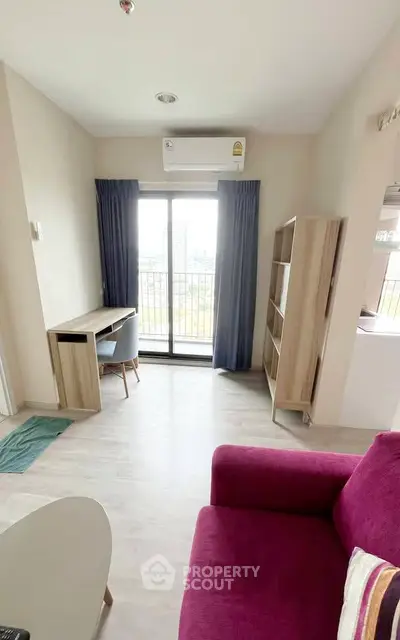 Modern living room with balcony view, featuring stylish furniture and natural light.