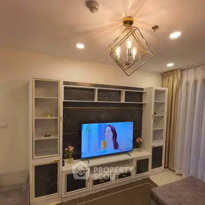 Elegant living room with modern TV unit and stylish lighting fixture.