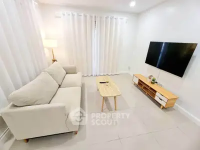 Modern living room with cozy sofa and wall-mounted TV, bright and inviting space.