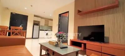 Modern living room with open kitchen, featuring sleek furniture and appliances for a cozy urban lifestyle.