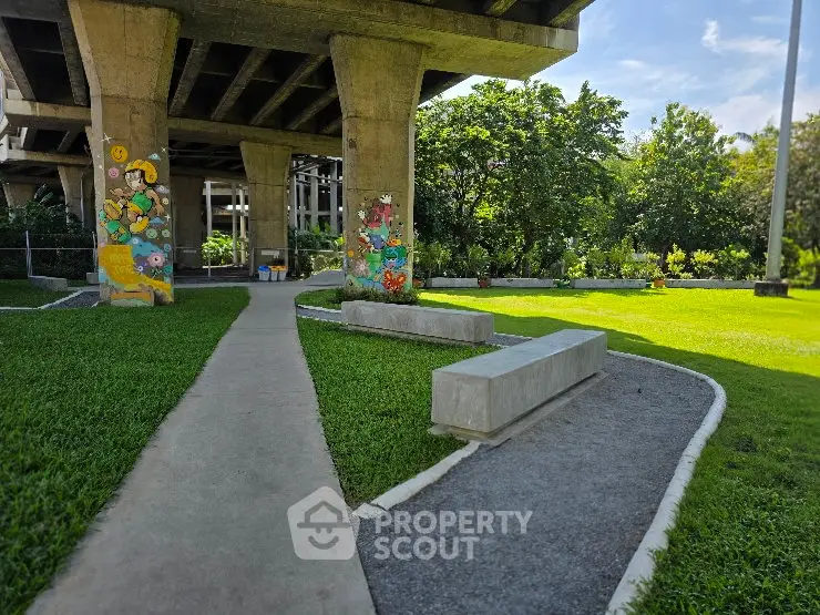 Charming urban park under a bridge with vibrant murals and lush greenery, perfect for relaxation and leisure.