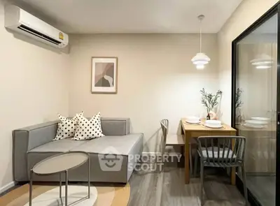 Modern living room with cozy dining area, featuring stylish furniture and elegant decor.