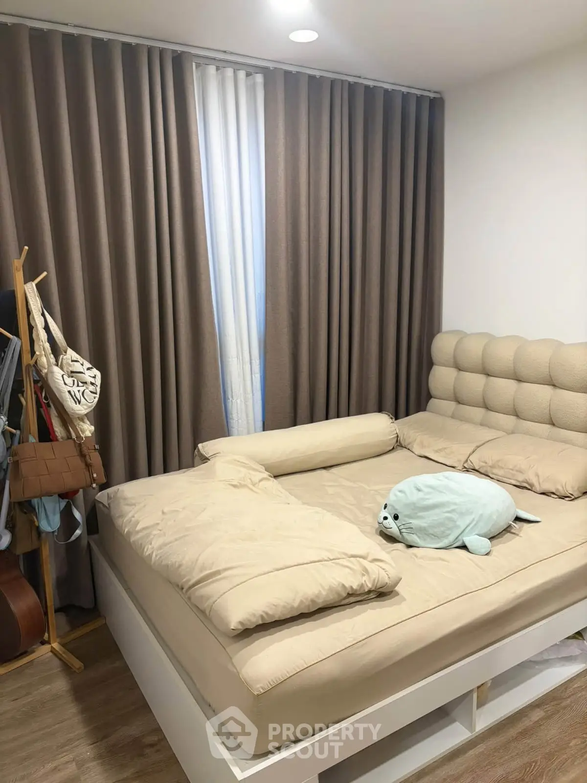 Cozy bedroom with plush bedding and elegant curtains, perfect for relaxation and comfort.
