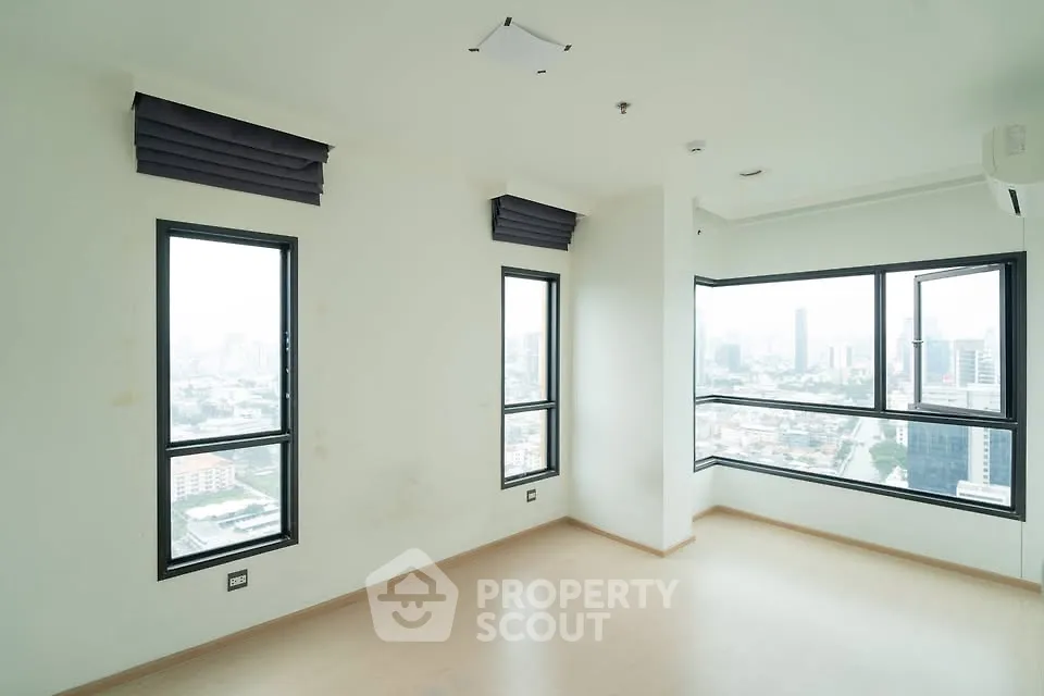 Bright corner unit with panoramic city views and large windows in modern apartment.