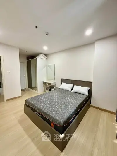 Spacious bedroom with modern design and ample natural light, featuring a comfortable bed and sleek flooring.