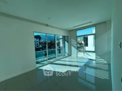 Spacious modern living room with large windows and glossy tiled floors