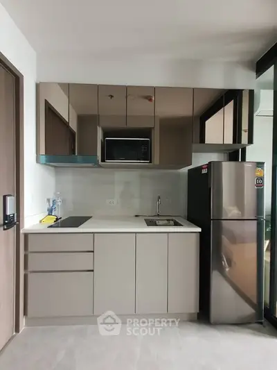 Modern kitchen with sleek cabinetry and stainless steel appliances in a compact layout.