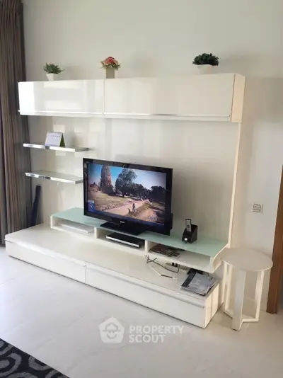 Modern living room with sleek white entertainment unit and flat-screen TV