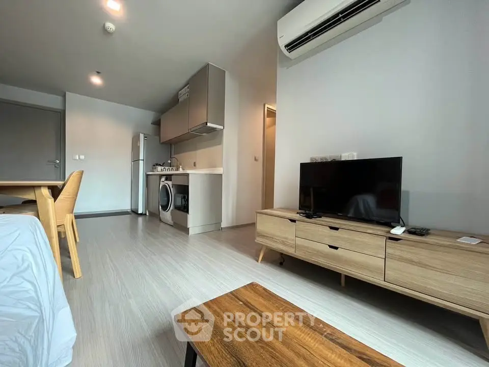 Modern living room with sleek furniture and integrated kitchen appliances in a stylish apartment.