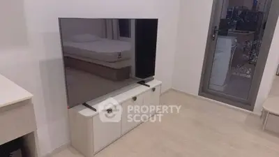 Modern living room with sleek TV and stylish furniture in a contemporary apartment.