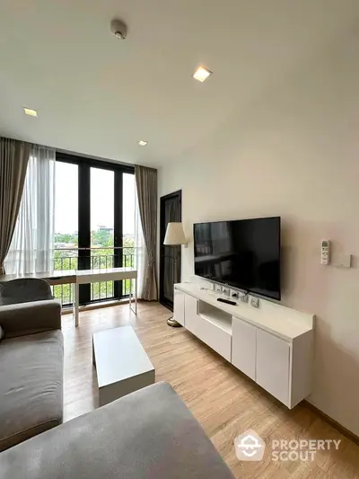 Modern living room with large TV and balcony view in stylish apartment