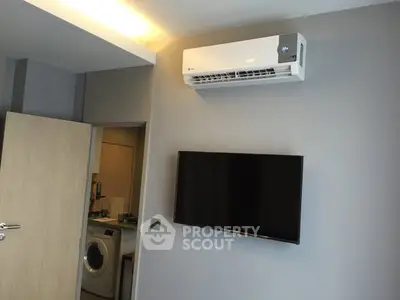 Modern living room with wall-mounted TV and air conditioning unit.