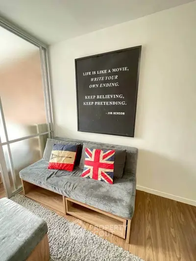 Cozy living room with stylish decor and unique wall art, featuring comfortable seating and wooden flooring.