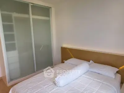 Modern bedroom with sleek sliding closet doors and stylish headboard lighting.