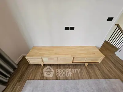 Modern wooden console table in stylish living room with hardwood floors and neutral decor.