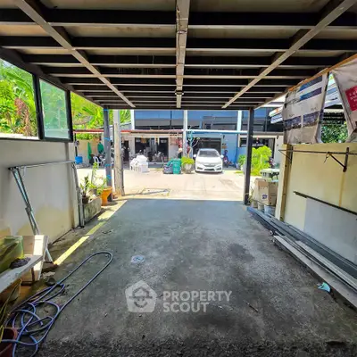 Spacious garage with open view to driveway and parked car, ideal for storage or workshop space.