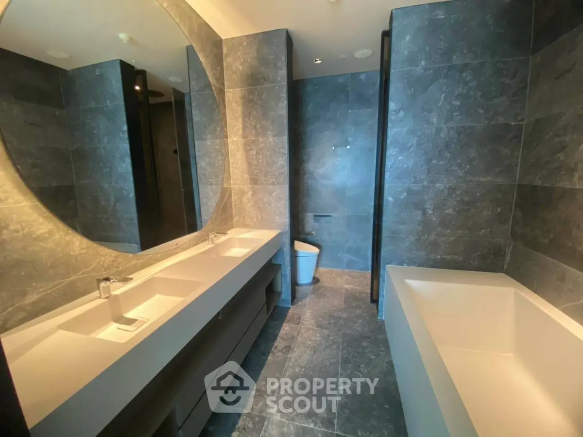 Luxurious modern bathroom with dual sinks and elegant bathtub in high-end property.