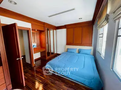 Cozy bedroom with wooden accents and large windows for natural light
