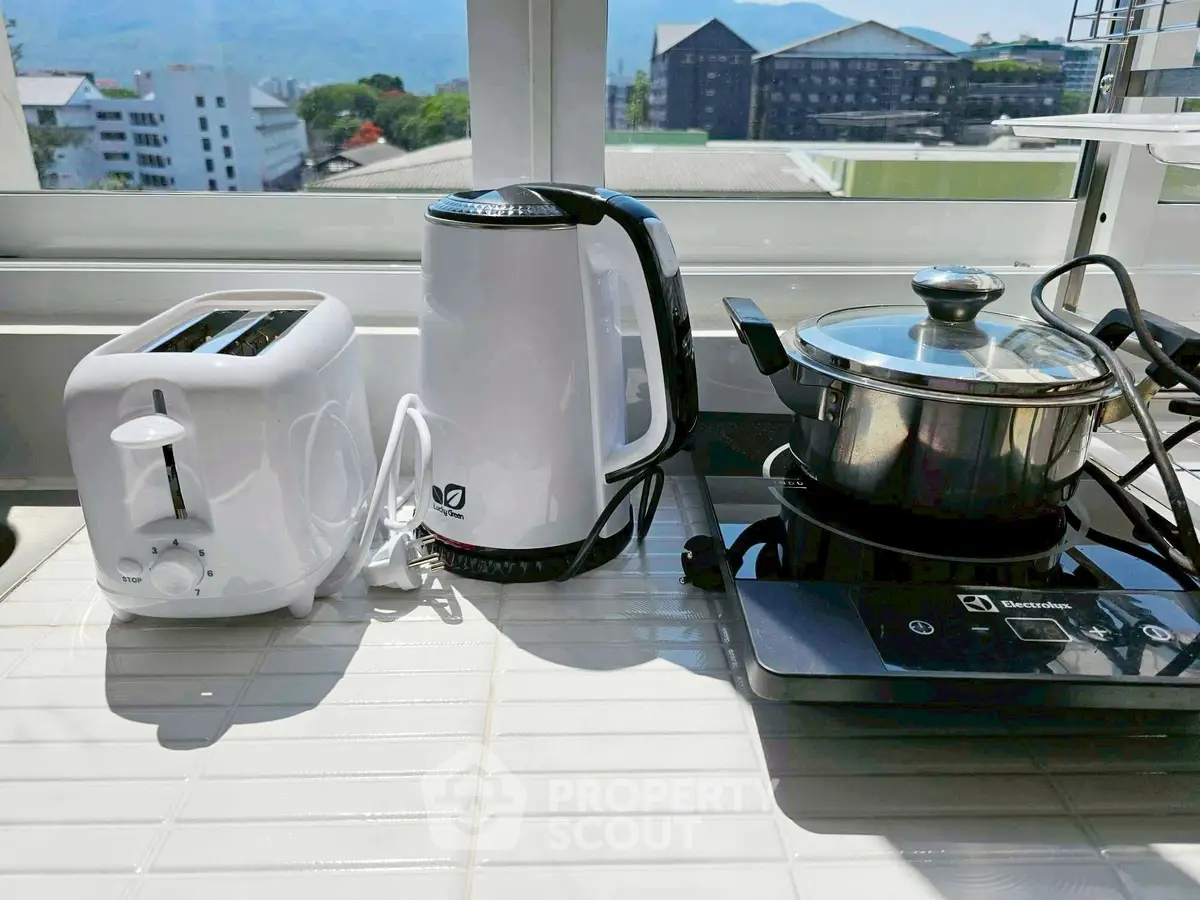 Modern kitchen appliances on a sunny countertop with a scenic view.
