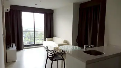 Modern living room with balcony view, featuring sleek furniture and natural light.