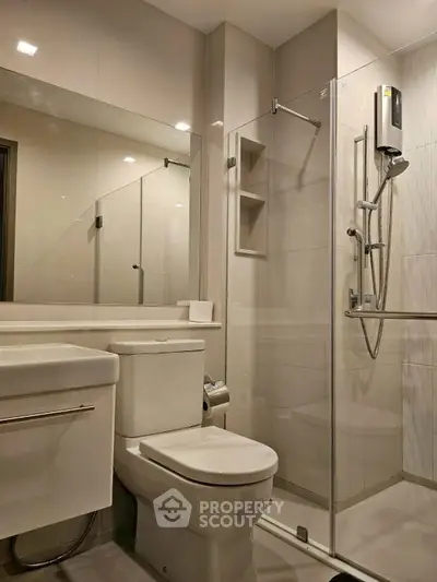 Modern bathroom with glass shower and sleek fixtures in contemporary apartment.