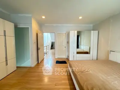 Spacious bedroom with modern furniture and wooden flooring