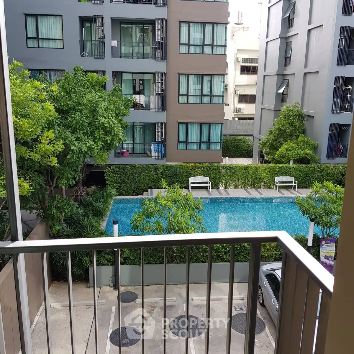 Modern apartment view with pool and lush greenery in urban setting