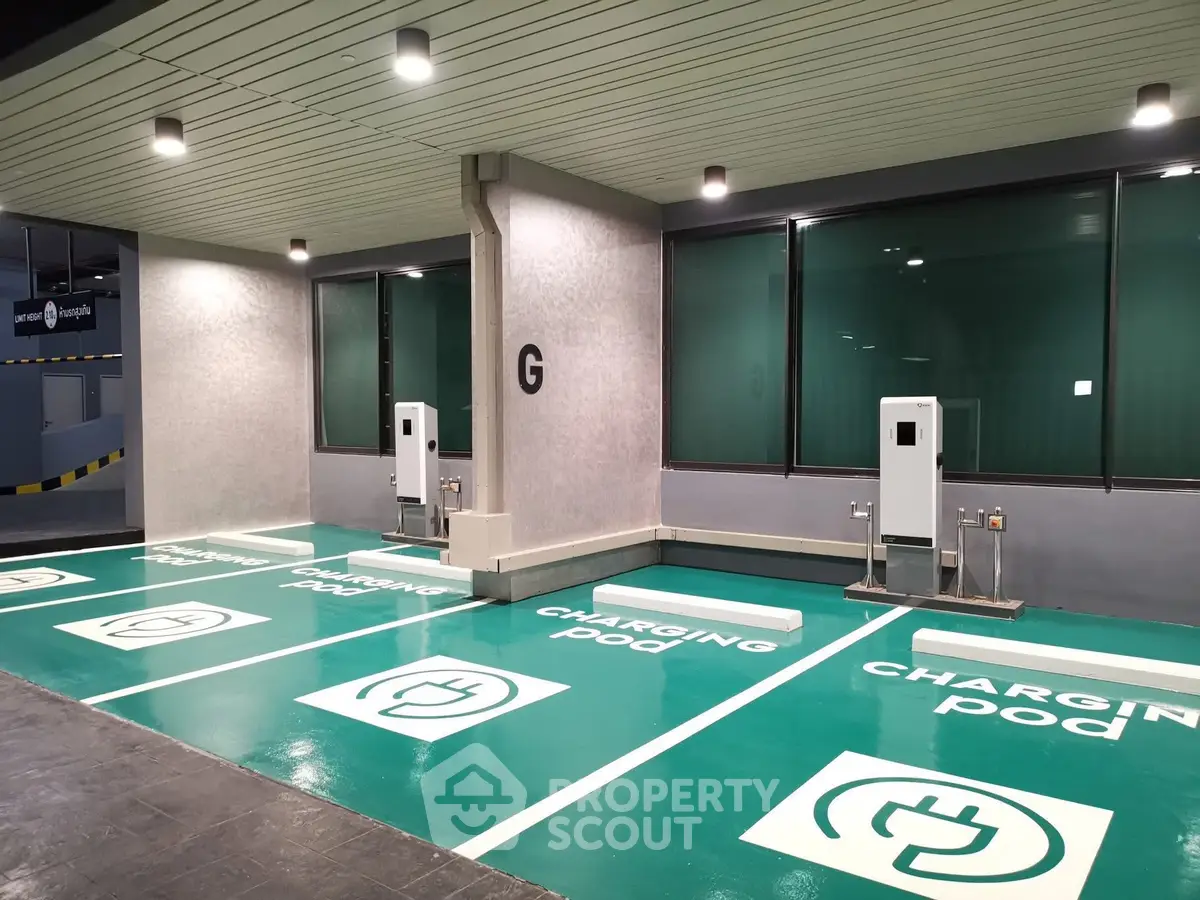 Modern electric vehicle charging station in a parking area with green charging pods.