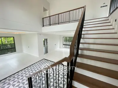 Spacious modern living room with high ceilings and elegant staircase