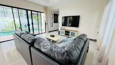 Modern living room with pool view and sleek leather sofa