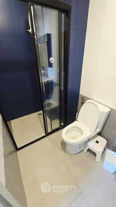 Modern bathroom with sleek shower and toilet in contemporary design.