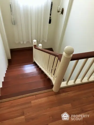 Elegant wooden staircase with natural light and classic railing design