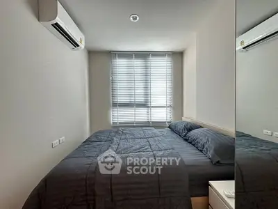 Modern bedroom with sleek design and natural light, featuring a comfortable bed and air conditioning.