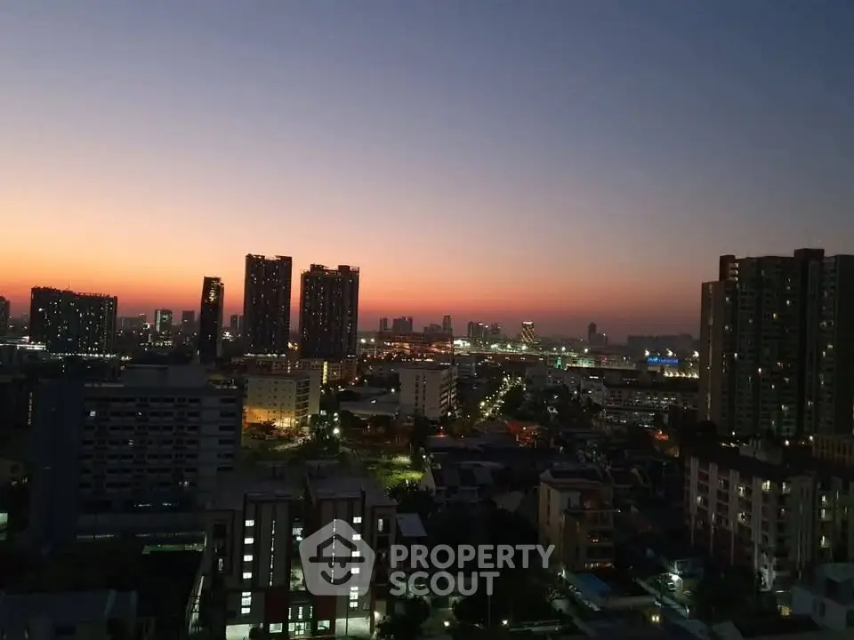 Stunning city skyline view at dusk with illuminated buildings and vibrant sunset colors.