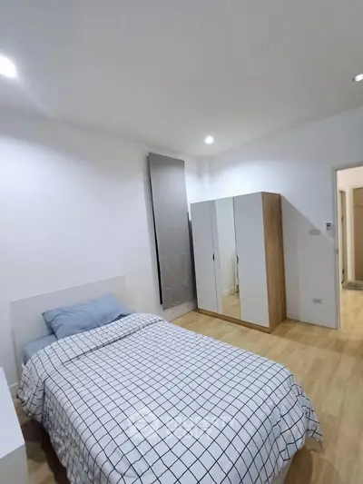 Modern bedroom with stylish wardrobe and cozy bed, perfect for relaxation.